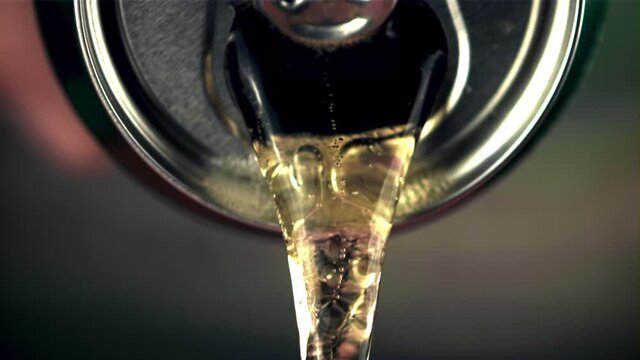 Super slow motion from the tin pours fresh beer. On a gray background.Filmed on a high-speed camera at 1000 fps.