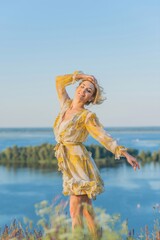Fototapeta na wymiar Blonde romantic woman in fluffy dress, pretty ladies outfit, girl in meadow at sunset