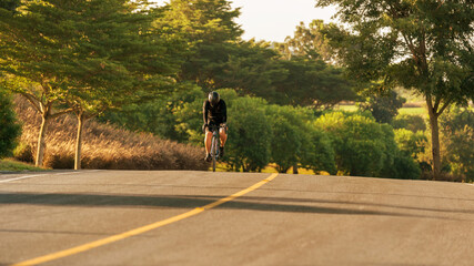 Sportman cyclist ride bicycle wearing sportsuite speed on country along road with green nature background,is sport for healthy.