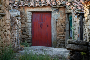 Narrow street with red entrance metallic door