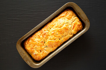 Homemade Cheesy Bread Loaf on a black surface, top view. Flat lay, overhead, from above.