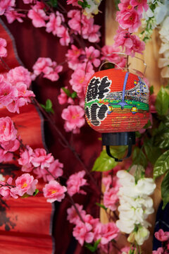 Blurred red and pink Japanese-style background with hieroglyphs, lantern and pink flowers