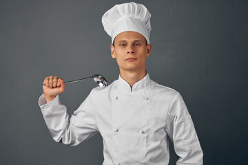 Cheerful chef with a ladle in his hands, professional cooking