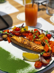 Roasted salmon steak with vegetables garnish