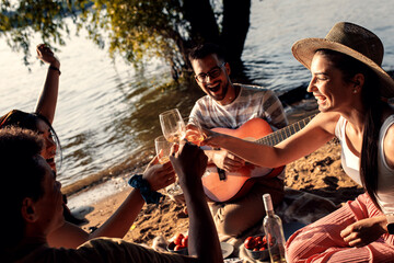 Diverse group of friends enjoying picnic by the river.