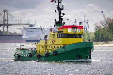TUGBOAT - Auxiliary vessel sails in the seaport background 