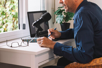 Middle-aged man conducting a podcast at home. Conceptual of lifestyle