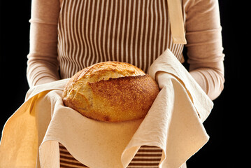 Baker holding loaf of homemade bread