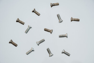 Collection of screw heads. Background of screws and dowels. Levitation of objects on a white...