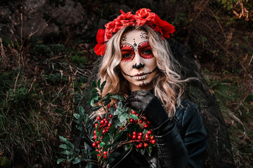 Closeup portrait of Calavera Catrina. Young woman with sugar skull makeup and red flowers. Dia de...