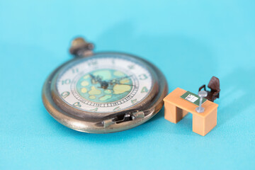 Pocket watch and empty workstation on blue background