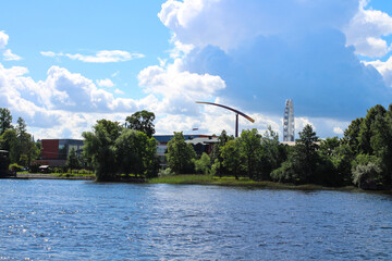 The view from the river to the trees and the amusement park that is not working due to the virus - a standing Ferris wheel, a rocket hanging motionless. St. Petersburg.