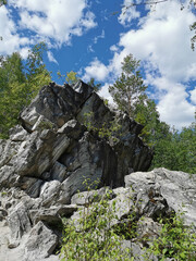 Catherine's marble cliff surrounded by trees in Ruskeala Mountain Park on a sunny summer day.