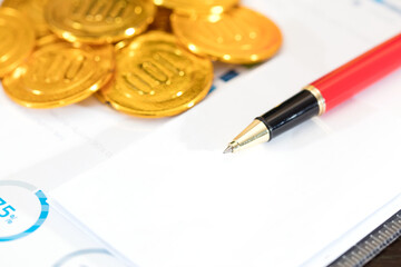 Gold coins and signature pen on the document