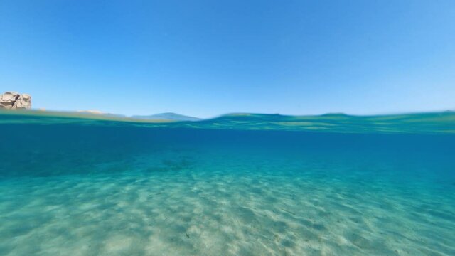 Split-shot, over-under shot. Stunning view of half underwater half sky with a beautiful and turquoise water. Liscia Ruja, Sardinia, Italy.