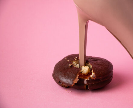 heel stiletto heel of  womans leather beige shoe breaks chocolate sponge cake with filling into pieces and crumbs. concept of proper healthy nutrition, rejection of unhealthy and highcalorie foods.