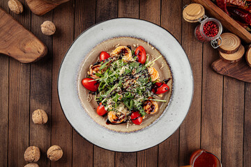 Top view on shrimp and arugula salad with tomatoes and parmesan