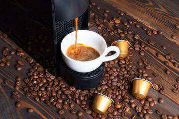 Automatic coffee machine with coffee capsules or pods pouring espresso drink. Making coffee in a...