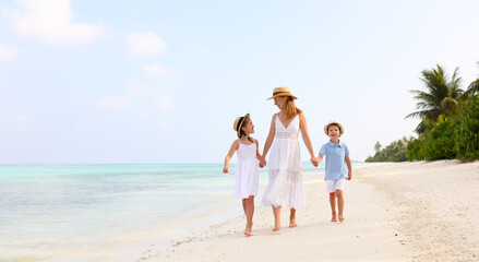 Mother with children walking on beach