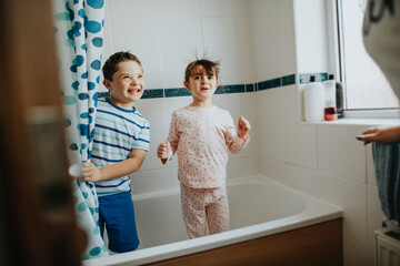 Sister and brother playing peekaboo in the bathroom