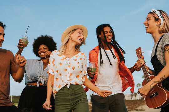 Friends singing and dancing at the beach