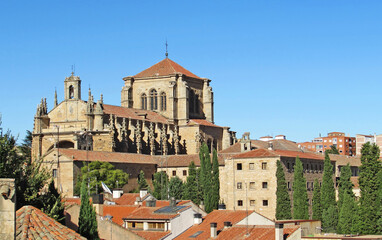 Fototapeta na wymiar The top of Convento de San Esteban towering over the roofs of Salamanca, Spain.