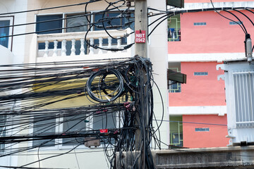 Messy electrical cables in thailand - many lines of cables chaotic set of interwoven, optical fiber...