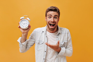 Positive fashionable guy with brown hair and red beard in white t-shirt and denim modern jacket...