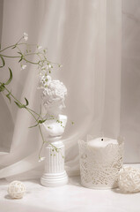 Interior minimalistic light gray background mock up. Gypsophila flowers, decorative balls, candlestick and female figurine. Shadows and sunlight. 