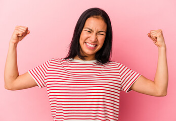 Young Venezuelan woman isolated on pink background showing strength gesture with arms, symbol of feminine power