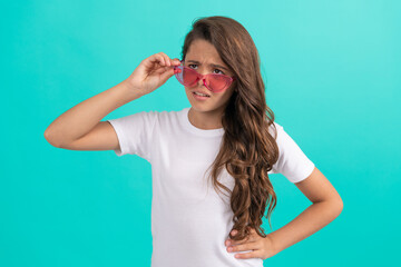 unhappy kid long curly hair in sunglasses casual style on blue background, fashion style