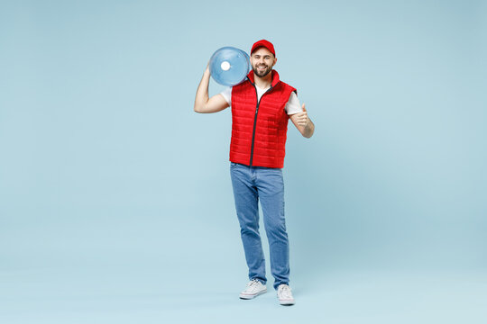 Full Size Body Length Delivery Guy Employee Man In Red Cap White T-shirt Vest Uniform Workwear Work Dealer Courier Hold Water Bottle Isolated On Pastel Blue Color Background Studio. Service Concept