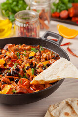 Pork stew with chorizo and black beans. Served with orange and seasoned with hot chili peppers. Perfect with tortillas.