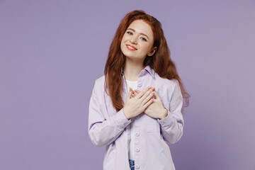 Smiling young redhead curly green-eyed woman 20s wears white T-shirt violet jacket put folded hands...