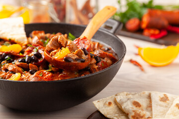 Pork stew with chorizo and black beans. Served with orange and seasoned with hot chili peppers. Perfect with tortillas.