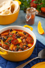 Pork stew with chorizo and black beans. Served with orange and seasoned with hot chili peppers. Perfect with tortillas.
