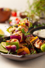 Grilled skewers with chicken, pepper, and onion. Served with sauce. Painted, bright background.