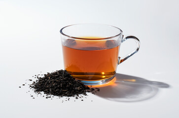 Black tea and tea leaves on white background