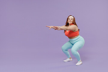 Fototapeta na wymiar Full length side view fun young chubby overweight plus size big fat fit woman in red top warm up training squating look camera isolated on purple background home gym. Workout sport motivation concept.