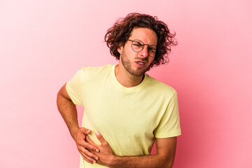 Young caucasian man isolated on pink bakcground having a liver pain, stomach ache.