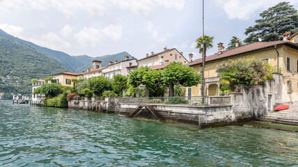 Fototapeta na wymiar picturesque houses on water at village on lake shore, Torno, Como, Italy