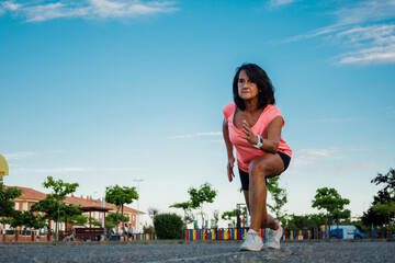 Hispanic woman in sprint position. Sportswear and brunette mature.