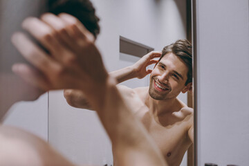 Young smiling satisfied happy attractive half naked topless caucasian brunette man 20s look at...