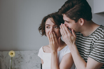 Close up young secret surprised couple two woman man 20s in casual clothes guy whisper gossip and...