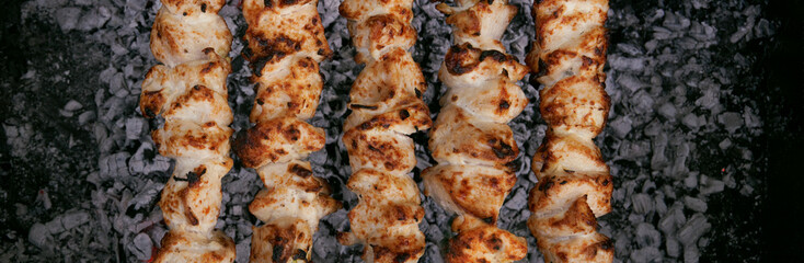 Cooking meat on the grill, barbecue, pieces of meat planted on a skewer. Roasting kebab on coals