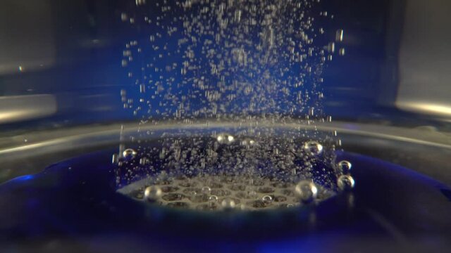 Gas bubbles rise in the bottle for ionization, structuring and enrichment and alkalinity of the water. The device is portable for drinking water. Close-up.