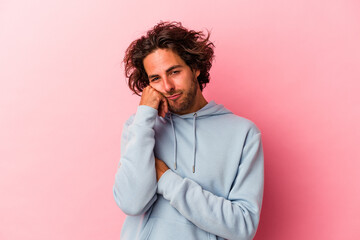 Young caucasian man isolated on pink bakcground who feels sad and pensive, looking at copy space.