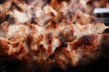Cooking meat on the grill, barbecue, pieces of meat planted on a skewer. Roasting kebab on coals
