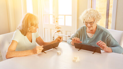 Zwei alte Frauen spielen Rummikub im Seniorenheim