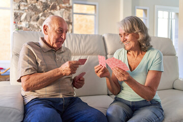 Senioren Paar im Ruhestand beim Karten spielen auf dem Sofa